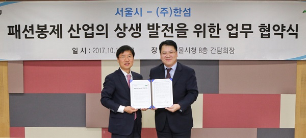 11일 서울시청 본관에서 김민덕 한섬 부사장(우측)과 서동록 서울시 경제진흥본부장이‘패션봉제 산업의 상생 발전을 위한 업무협약(MOU)’을 체결하고 기념촬영을 하고 있다. 현대백화점그룹 제공