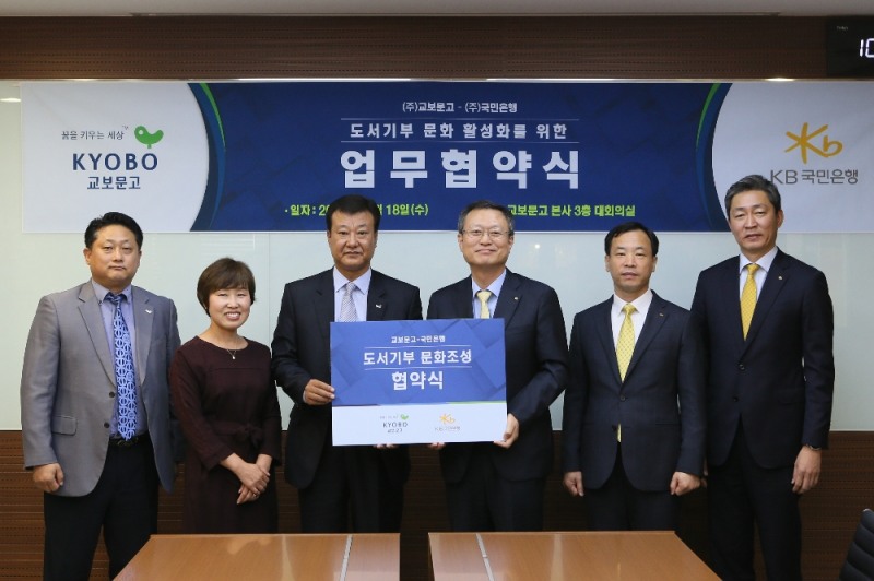 △신홍섭 KB국민은행 소비자브랜드전략그룹대표(왼쪽 네 번째)와 김형면 교보문고 점포사업본부장(왼쪽 세 번째)이 업무협약 후 관계자들과 기념촬영하고 있다./사진=KB국민은행
