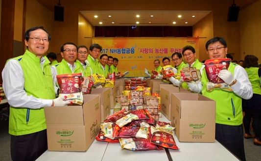 9일 서대문 농협은행 신관에서 NH농협금융지주 김용환 회장 및 자회사 CEO들이 농산물 꾸러미를 포장하고 있다. 왼쪽 첫 번째부터 김용환 농협금융지주 회장, 서기봉 NH농협생명 대표, 신일승 NH농협손해보험 부사장, 최상록 NH저축은행 대표, 오른쪽 첫 번째부터 이경섭 NH농협은행장, 고태순 NH농협캐피탈 대표, 한동주 NH-AMUNDI 자산운용 대표, 김원규 NH투자증권 대표. / 사진제공= 농협금융지주