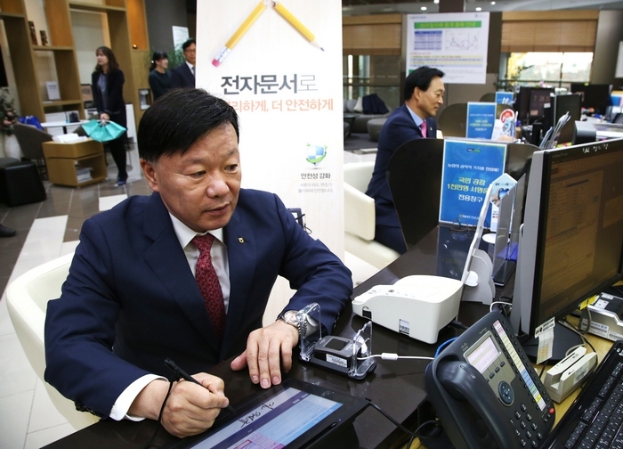 NH투자증권은 증권업계 최초로 전국 영업점에 전자문서 업무를 도입했다. 김원규 사장이 현장에서 시연하고 있다./자료=NH투자증권