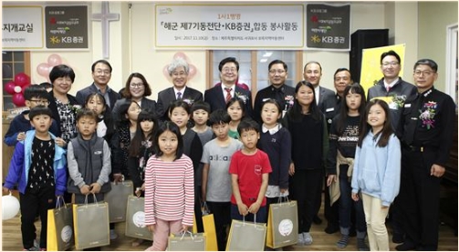 지난 10일 제주 보목지역아동센터에서 열린 '무지개교실'행사에서 KB증권 전병조사장(뒷줄 오른쪽에서 여섯번째)과 김정수 해군 7기동전단장(뒷줄 오른쪽에서 다섯번째)을 비롯한 KB증권 임직원들과 해군장병 및 보목지역아동센터 관계자들과 지역어린이들이 기념 촬영 포즈를 취하고 있다.