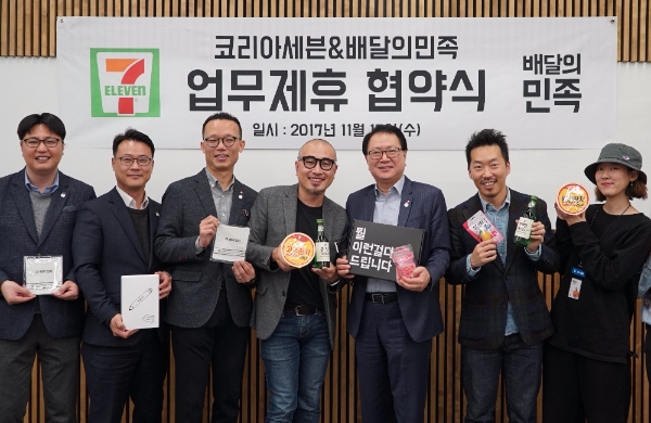 15일 정승인 세븐일레븐 대표(우측 세번째)와 김봉진(우측 네번째) 우아한형제들 대표, 오재용 세븐일레븐 상품부문장(우측 다섯번째) 등 관계자들이 업무협약을 체결한 뒤 기념촬영을 하고 있다.코리아세븐 제공