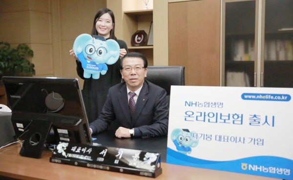 △NH농협생명 서기봉 사장이 온라인 보험 출시를 맞아 PC를 통해 직접 암보험에 가입했다. / 사진=NH농협생명