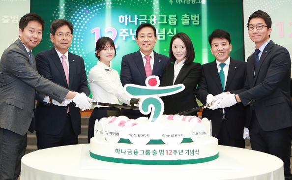 하나금융그룹은 4일 명동 사옥 대강당에서 그룹 및 지주사 출범 12주년을 기념하는 행사를 개최했다. 김정태 하나금융그룹 회장(사진 왼쪽에서 네번째), 김병호 하나금융그룹 부회장(사진 왼쪽에서 두번째), 함영주 KEB하나은행장(사진 왼쪽에서 여섯번째)이 참석 직원들과 함께 하나금융그룹 출범 12주년을 기념하는 기념케이크를 자르고 있다. / 사진제공= KEB하나은행