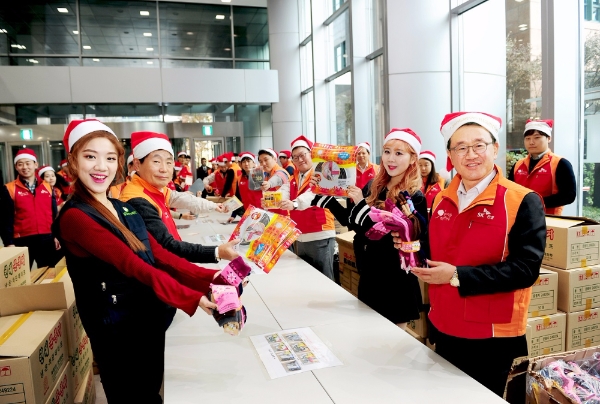 조기행 SK건설 부회장(사진 오른쪽)과 임직원, 베이비부 멤버들(남색조끼 착용)이 6일 밀알복지재단과 함께 방한키트를 제작했다. 사진=SK건설.