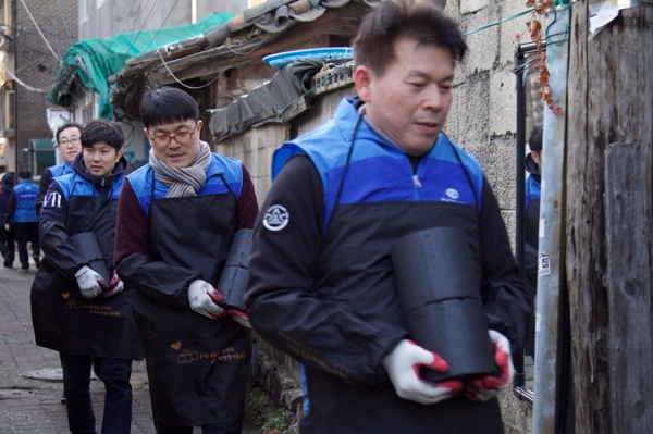 △DGB생명 임직원들이 주민들에게 전달 될 연탄을 나르고 있다. / 사진=DGB생명