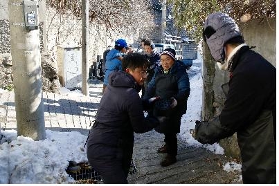 13일 서울시 정릉동에서 군인공제회 임직원들이 사랑의 연탄 나눔 행사에 참여해 연탄을 나르고 있다.  