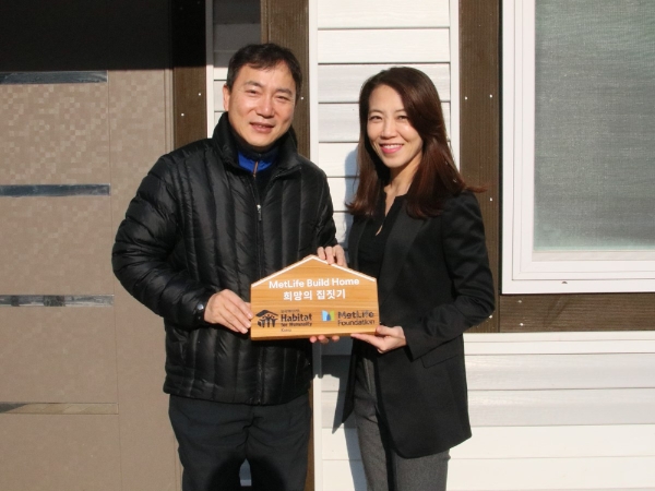 △지난 16일 강원도 홍천에서 진행된 ‘메트라이프 희망의 집 헌정식’에서 메트라이프코리아재단 황애경 사무국장(사진 오른쪽)과 한국해비타트 이종태 사업관리본부장 (사진 왼쪽)이 헌정할 문패를 들고 기념촬영을 하고 있다. / 사진=메트라이프생명