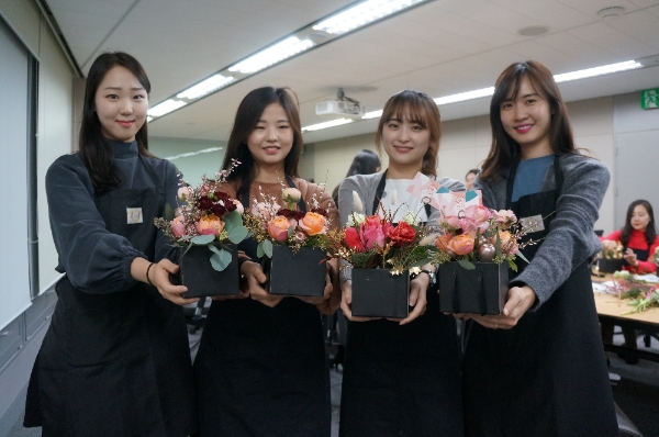 △흥국생명의 미혼모 시설 꽃바구니 전달 활동에 참여한 인원들이 직접 제작한 꽃바구니와 함께 기념 촬영을 하고 있다. / 사진=흥국생명