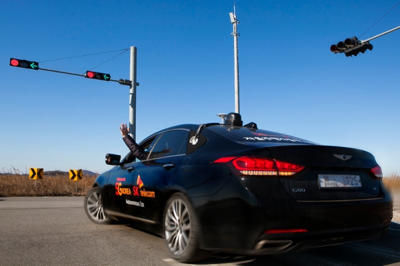 △자율주행차가 교통안전공단 K-City 내 테스트트랙에서 신호에 맞춰 좌회전하고 있다. 신호등 사이에 자리잡은 기둥 끝에 5G안테나가 설치돼있다 /사진=SK텔레콤