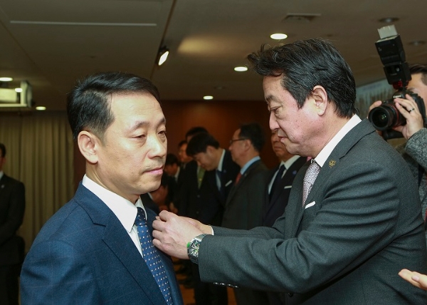 이웅렬 코오롱그룹 회장(사진 오른쪽)이 2일 과천 코오롱타워에서 열린 '그룹 통합 시무식'에서 올해 경여지침인 'CATCH 2018'을 상징하는 'CAT' 배지를 직원에게 달아주고 있다. 사진=코오롱그룹.