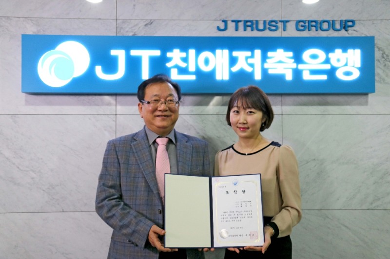 △(왼쪽부터) 윤병묵 JT친애저축은행 대표이사와 최빛나 경영본부 과장보가 표창장을 들고 기념촬영을 하고 있다./사진=JT친애저축은행