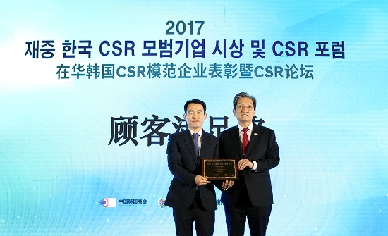 두산인프라코어가 ‘2017 재중 한국 CSR 모범기업’ 고객만족부문에서 최우수상을 수상했다. 회사 대표로 시상식에 참석한 중국법인(DICI) 박인복 부장이 노영민 주중한국대사(오른쪽)로부터 상을 수상하고 있다. 사진=두산인프라코어.
