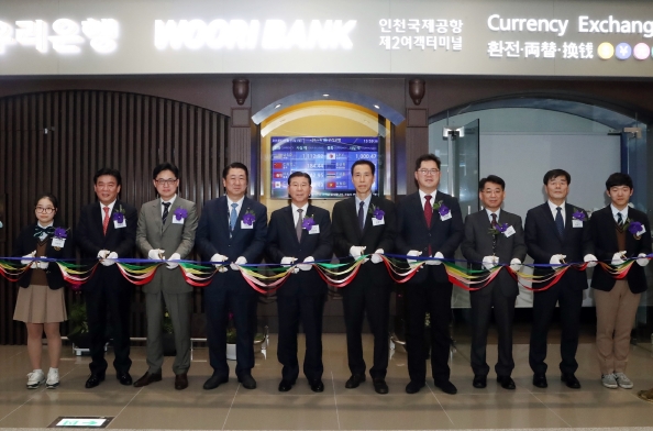 우리은행은 15일 오후 인천광역시 중구 운서동 인천국제공항 제2청사에서 ‘인천국제공항 제2여객터미널 영업점’ 개점식을 실시했다. 장안호 우리은행 국내부문장(사진 왼쪽 다섯번째)이 안정준 인천국제공항공사 경영혁신본부장(사진 왼쪽 일곱번째), 손홍기 인천출입국관리소장(사진 왼쪽 여섯번째), 김종대 대한항공 전무(사진 왼쪽 네번째) 등 주요 인사와 테이프 커팅식을 하고 있다. / 사진제공= 우리은행