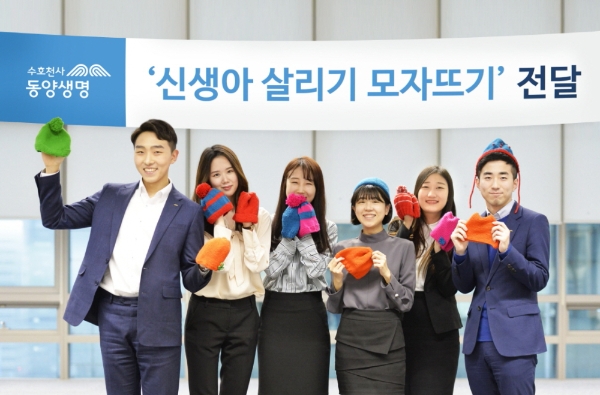 △동양생명의 신생아 살리기 모자뜨기 캠페인에 참여한 직원들이 완성된 모자를 들고 포즈를 기념촬영을 하고 있다. / 사진=동양생명