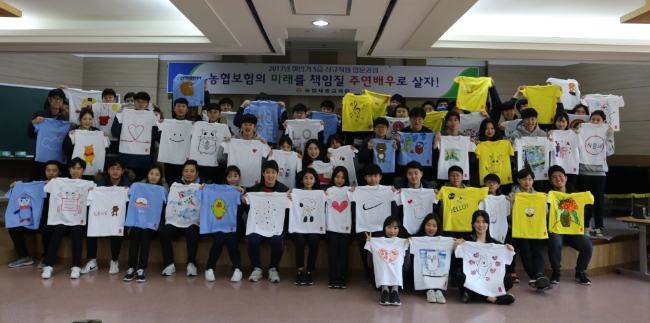 △봉사활동에 참여한 농협생명과 농협손해보험의 신입사원들이 직접 제작한 티셔츠를 들고 기념촬영을 하고 있다. / 사진=NH농협생명