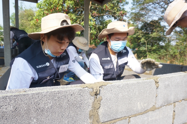 △코리안리 신입사원 해외봉사단이 태국 아유타야에서 주택 외벽 벽돌 쌓기 작업을 하고 있다. / 사진=코리안리재보험