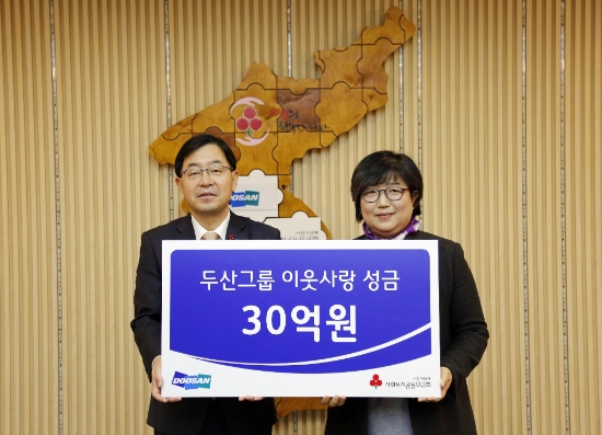 12일 박완석 두산그룹 부사장(왼쪽)이 김연순 사회복지공동모금회 사무총장에게 성금 30억원을 전달했다. 사진=두산그룹.