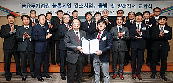 ▲ 금융투자협회와 주요 21개 증권사는 작년 말 국내 최초의 공동 블록체인 컨소시엄을 구성했다. 박선무 NH투자증권 상무(앞줄 왼쪽), 이경준 데일리인텔리전스 대표(앞줄 오른쪽).