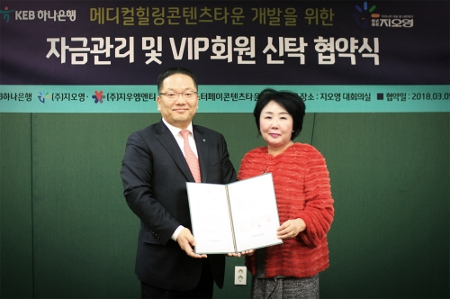 KEB하나은행은 5일 (주)지우엠앤티 및 마스터페이콘텐츠타운사업단과 내외국인 의료관광 및 바이오 융합 사업의 '신탁자금관리'를 위한 전략적 업무협약을 체결했다고 밝혔다. 이날 협약식에서 이호성 KEB하나은행 중앙영업그룹 전무(사진 왼쪽)와 (주)지우엠앤티 조선혜 회장(사진 오른쪽)이 협약식 후 기념촬영을 하고 있다. / 사진= KEB하나은행