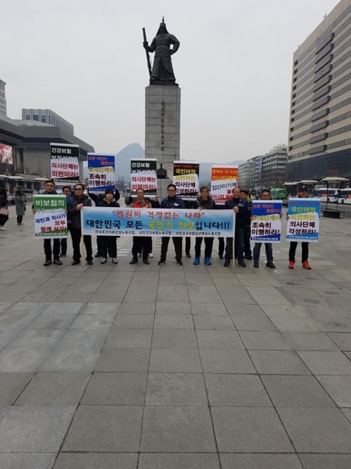 △국민건강보험노동조합·국민건강보험일산병원노동조합이 18일 오후 광화문 이순신동상 앞에서 문재인케어를 지지하는 피켓시위를 하고 있다. / 사진=국민건강보험노동조합