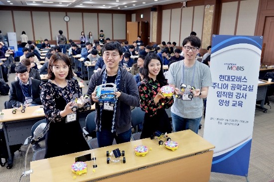 현대모비스 직원 주니어공학교실 강사들이 한국공학한림원과 한양대 청소년 과학기술진흥센터 소속 강사진들의 설명을 들으며 만든 어린이 과학 키트를 들어보이고 있다. 사진=현대모비스.