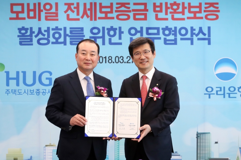 우리은행은 27일 서울 중구 본점에서 '우리은행-주택도시보증공사, 모바일 전세보증금 반환보증 활성화를 위한 업무협약’을 체결했다. 이창재 부동산금융그룹 그룹장(사진 오른쪽)이 김기돈 주택도시보증공사 금융사업본부 본부장과 기념촬영을 하고 있다. / 사진= 우리은행