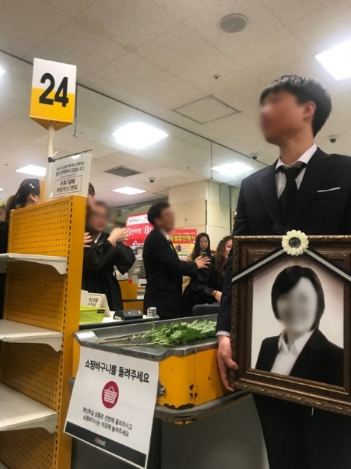 2일 오후 서울 구로구에 위치한 이마트 구로점에서 지난달 31일 근무 도중 사망한 A씨의 유가족들이 생전 고인이 근무했던 계산대에서 추모 행사를 진행하고 있다. 신미진기자