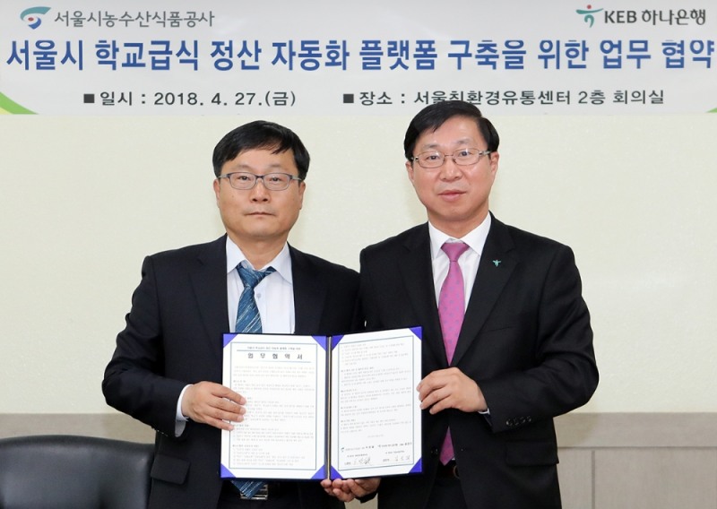 KEB하나은행은 27일 오전 강서구 소재 서울친환경유통센터에서 서울시농수산식품공사와 학교 급식업무 정산 자동화 플랫폼 구축을 위한 업무 협약을 체결했다. 김인석 KEB하나은행 기업사업본부 전무(사진 오른쪽)와 노광섭 서울특별시농수산식품공사 친환경유통센터장이 협약식 후 기념촬영을 하고 있다. / 사진= KEB하나은행