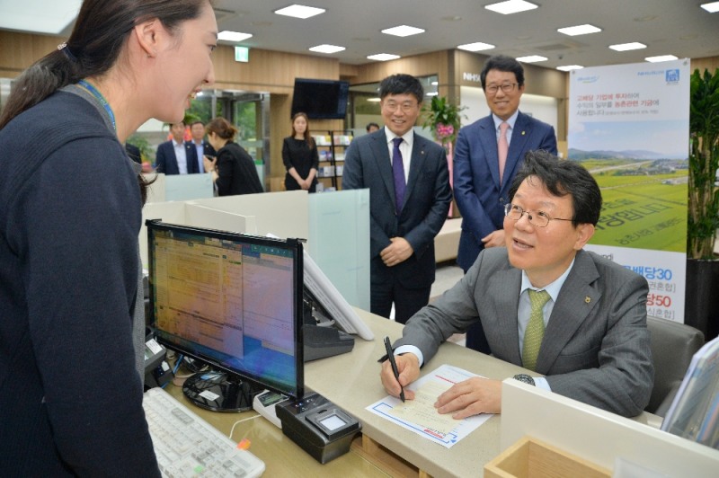 17일 농협은행 여의도문화지점에서 김광수 농협금융지주 회장이 농가소득 확대 지원을 위해 ‘NH-Amundi 농촌사랑 고배당 적립식 펀드'를 가입하고 있다. / 사진= 농협금융지주