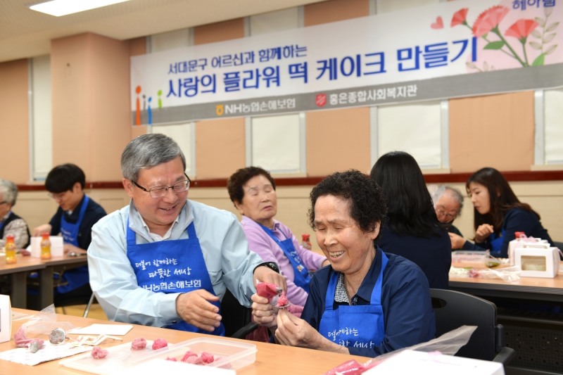△NH농협손해보험 오병관 대표이사(좌측)가 '사랑의 플라워 떡 케이크 만들기' 행사에 참여해 어르신들과 뜻깊은 시간을 보내고 있다. / 사진=NH농협손해보험
