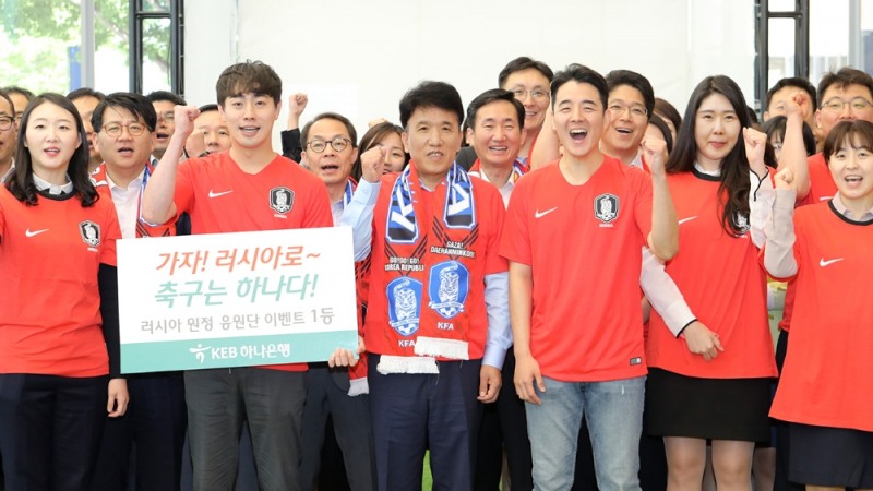KEB하나은행은 23일 오전 한국축구국가대표팀의 선전을 기원하고 K리그 흥행 분위기 조성을 위한 'KEB하나 축구놀이터'를 개관했다. 개관식 행사에서 함영주 KEB하나은행장(맨 앞줄 왼쪽에서 세번째)이 러시아 원정응원단 이벤트 수상자 및 직원들과 함께 기념촬영을 하고 있다. / 사진= KEB하나은행
