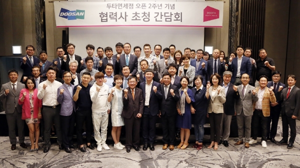 조용만 두타면세점 BG장(맨 앞줄 좌측에서 여덟번째)과 협력사 대표들이 지난 24일 서울 JW 메리어트 동대문에서 두타면세점 오픈 2주년 간담회를 개최하고 기념촬영을 하고 있다. 두산 제공