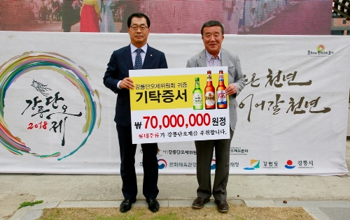 이종훈 롯데주류 대표(좌)와 조규돈 강릉단오제위원회 위원장이 14일 후원금 전달식을 갖고 기념촬영을 하고 있다. 롯데주류 제공