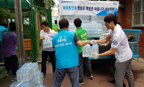 하이트진로 임직원들이 20일 서울 영등포구 쪽방촌에서 생수 전달 봉사활동을 진행하고 있다. 하이트진로 제공 