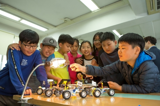 서울 개원초등학교 학생들이 주니어 공학교실에서 현대모비스 직원 강사들의 도움을 받아 태양광 자동차를 만들고 작동해보고 있다. 사진=현대모비스.