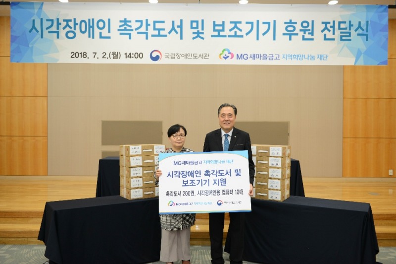 △국립중앙도서관에서 ‘시각장애인 촉각도서 및 보조기기 전달식’을 개최하고 정기애 국립장애인도서관장(왼쪽)과 박차훈 MG새마을금고 지역희망나눔재단 이사장(오른쪽)이 기념촬영을 하고 있다./사진=새마을금고중앙회