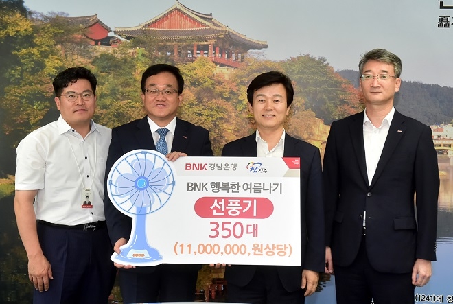 BNK경남은행 김영모 상무(사진 왼쪽 두번째)가 진주시 조규일 시장(사진 오른쪽 두번째)에게 ‘2018 행복한 여름 나기 선풍기 증서’를 전달하고 있다. / 사진 = BNK경남은행