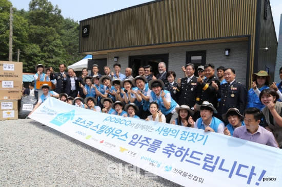 19일 포스코가 포항시 대송면 대각리에서 포스코 제 50호 스틸하우스 준공식을 열고 화재피해 가정에 이를 기증했다. 이날 준공식에서 포스코 입직원 및 대학색 봉사단원들이 기념촬영을 하고있다. 사진=포스코.