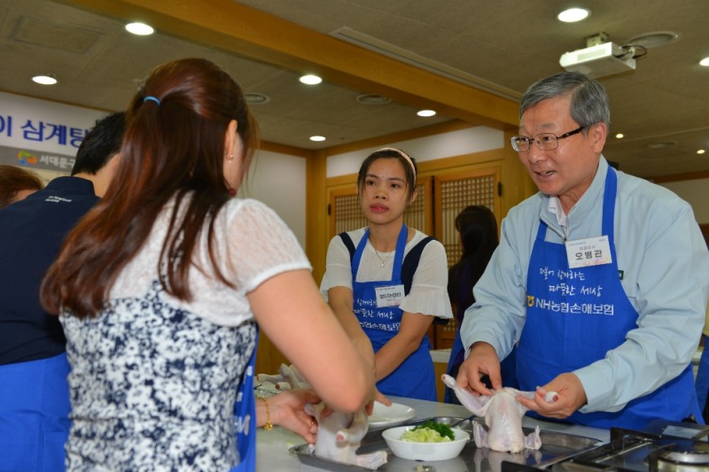 △NH농협손해보험 오병관 대표이사(사진 오른쪽)와 헤아림 봉사단이 다문화가정 이주여성들과 함께 삼계탕을 만들고 있다. / 사진=NH농협손해보험