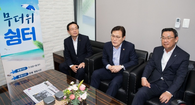 최종구 금융위원장(사진 가운데)은 30일 서울 종로구 우리은행 YMCA지점에 무더위 쉼터를 방문해 직원들을 격려했다. 최종구 금융위원장이 은행점포 내 무더위 쉼터를 이용중인 고객들과 이야기를 하고 있다. 왼쪽부터 손태승 우리은행장, 최종구 금융위원장, 김태영 은행연합회장. / 사진= 금융위원회