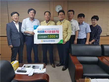 △고태순 NH농협캐피탈 대표(왼쪽에서 네번째)가 폭염피해 복구지원 물품인 스프링쿨러 1000개 전달 후 기념촬영을 하고 있다./사진=NH농협캐피탈