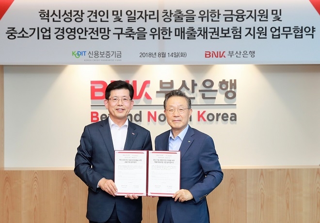 윤대희 신용보증기금 이사장(사진 오른쪽)과 빈대인 부산은행 은행장(사진 왼쪽)이 14일 부산은행 본점에서 열린 혁신성장・일자리 창출 금융지원 및 매출채권보험 활성화 업무협약에서 기념촬영을 하고 있다. / 사진 = 신용보증기금