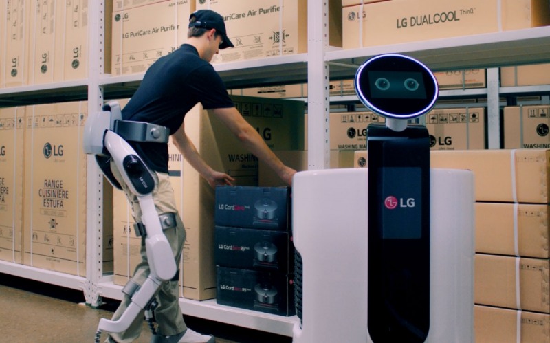 △‘LG 클로이 수트봇’을 착용한 작업자가 물류센터에서 상품을 쇼핑카트로봇에 옮겨담고 있는 모습
