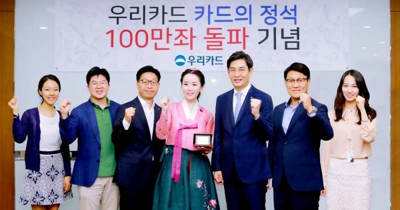 △30일 우리카드 본사에서 진행된 '카드의정석' 100만좌 돌파 기념식에서 정원재 우리카드 사장(왼쪽에서 다섯번 째)이 김현정 한국화가(왼쪽에서 네번째)에게 감사의 표시로 기념카드를 전달하고, 상품개발에 참여한 유공직원 5명과 함께 기념 촬영을 하고 있다./사진=우리카드