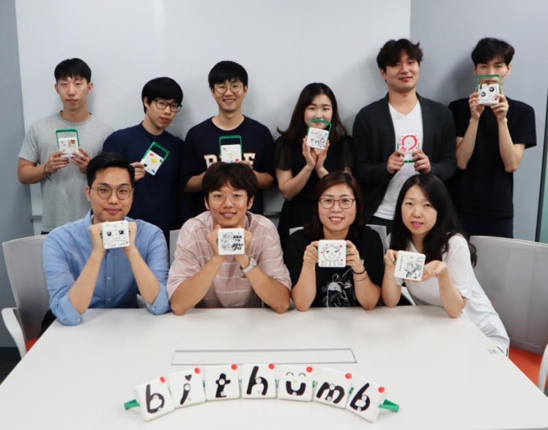 빗썸 직원들이 직접 만든 태양광랜턴을 들고 기념촬영을 하고 있다./사진=빗썸