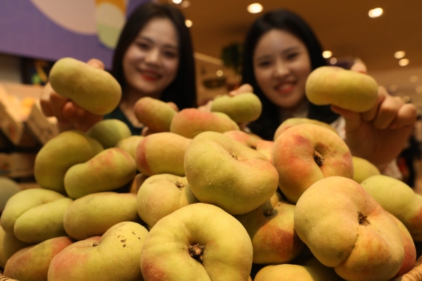4일 오전 소공동에 위치한 롯데백화점 본점에서 직원들이 ‘납작 복숭아’를 소개하고 있다. /사진=롯데백화점.