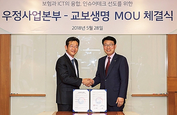 ▲ 김욱 교보생명 디지털혁신담당 전무(오른쪽), 김도균 우정사업본부 부이사관(보험기획과장)이 지난 5월 블록체인 기반 보험금 자동청구 시스템 구축을 위한 포괄적 업무협약(MOU)에서  기념촬영을 하고 있다. 사진 = 교보생명