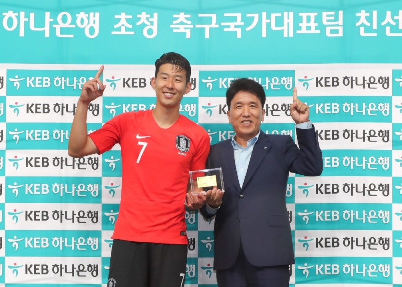 지난 7일 고양종합경기장에서 개최된 남미의 다크호스 코스타리카와의 국가대표 A매치 평가전 직후 함영주 KEB하나은행장(사진 오른쪽)이 그룹과 은행의 광고모델이자 대한민국 축구 국가대표 아이콘인 손흥민 선수(사진 왼쪽)에게 KEB하나은행의 홍보대사 명함을 전달하고 기념촬영을 하고 있다. / 사진= KEB하나은행