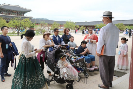 현대모비스가 장애아동을 둔 15개 가정을 초청해 진행한 가을여행에서 경복궁을 방문한 참가자들이 현장에서 설명을 듣고 있다. 사진=현대모비스.